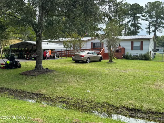 a front view of a house with a garden and trees