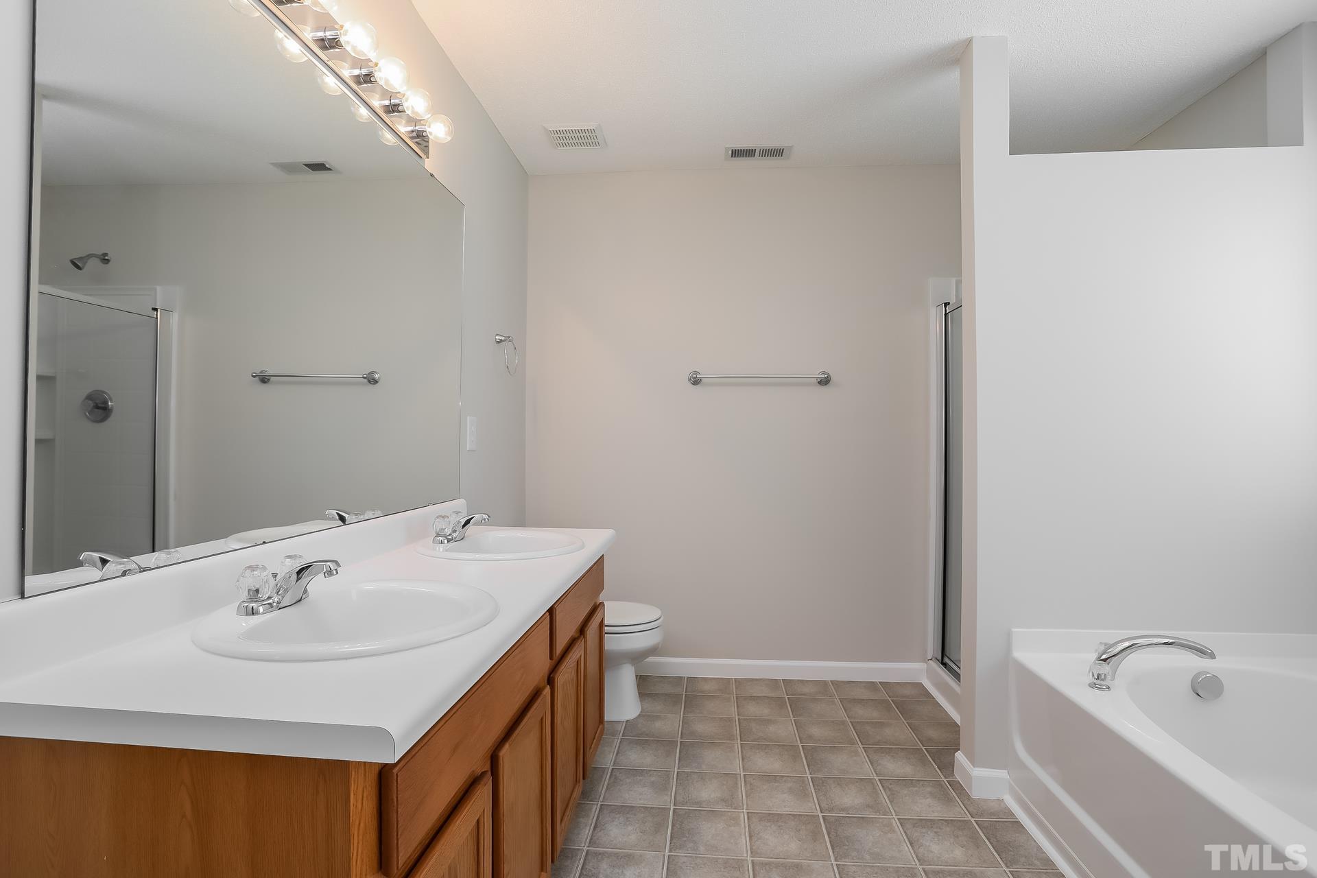 3618 Mountain Brook Circle Durham, NC 27704 - Photo 12 of 15 a bathroom with a sink a bathtub and a mirror