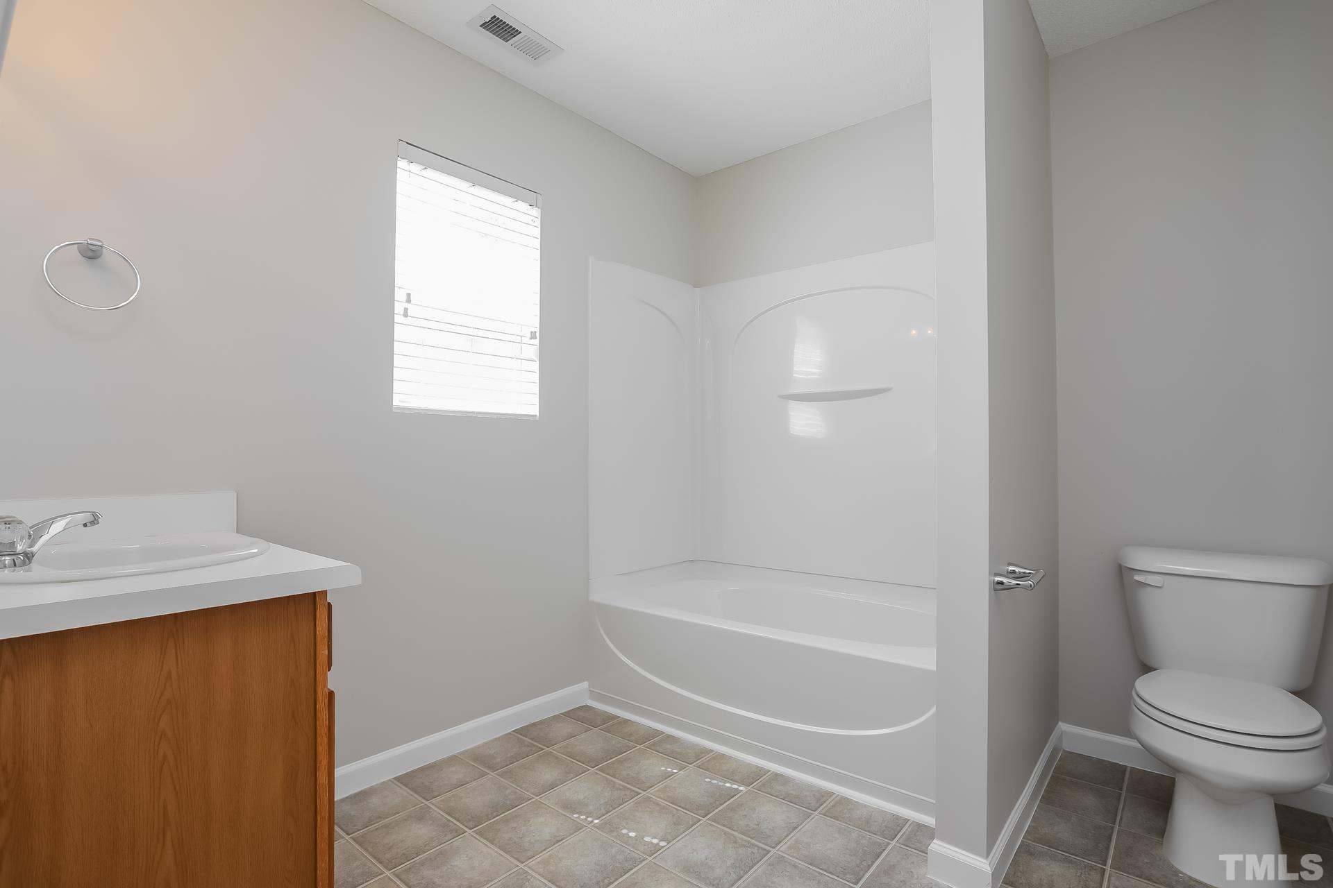 3618 Mountain Brook Circle Durham, NC 27704 - Photo 14 of 15 a bathroom with a granite countertop sink a toilet and shower