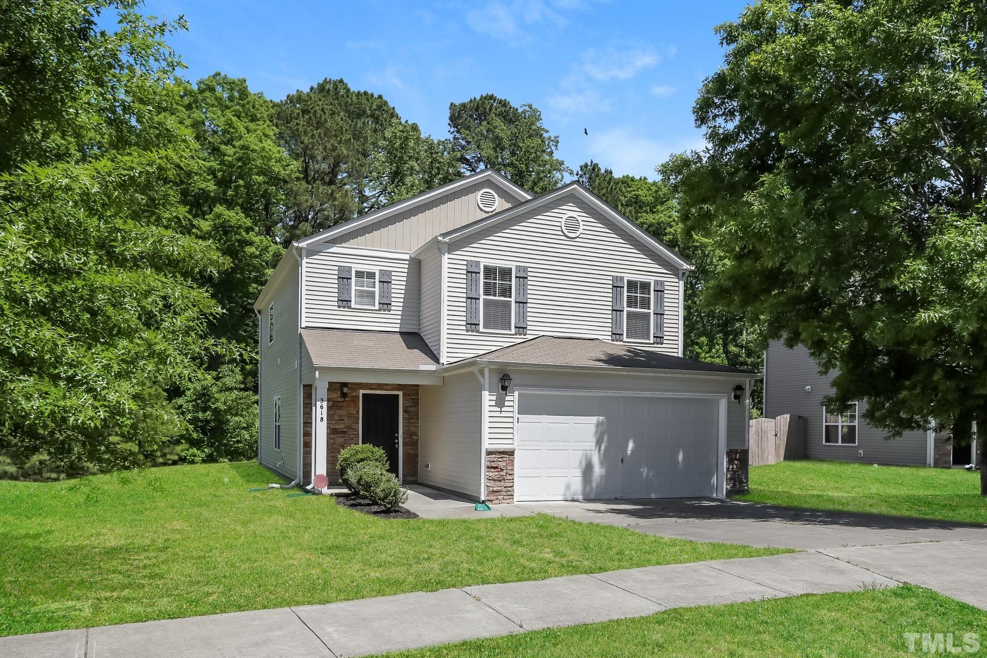 3618 Mountain Brook Circle Durham, NC 27704 - Photo 2 of 15 a front view of a house with a garden and trees