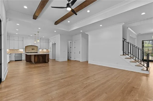 a kitchen with stainless steel appliances granite countertop a sink a stove and a wooden floors