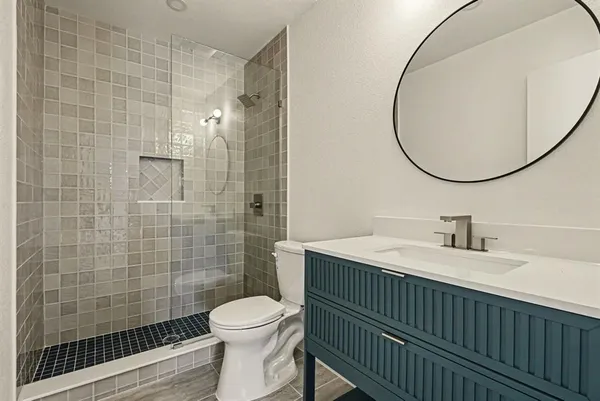 a bathroom with a sink a toilet and shower