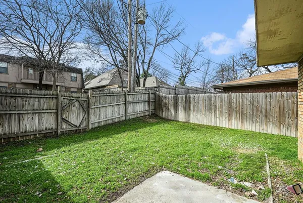 a view of backyard with wooden fence
