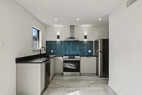 a kitchen with stainless steel appliances granite countertop a stove and a refrigerator