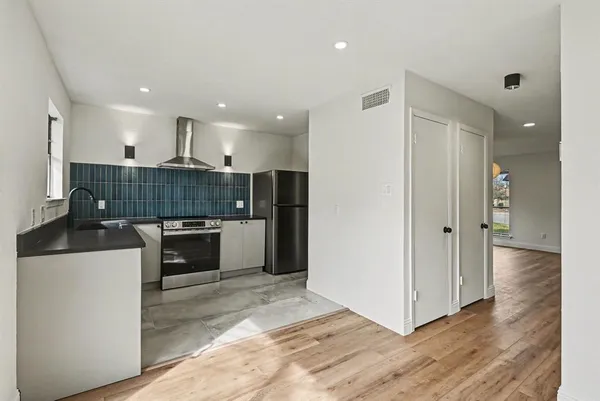 a kitchen with kitchen island granite countertop a refrigerator and a stove top oven