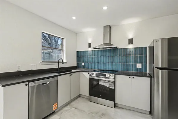 a kitchen with kitchen island a sink stainless steel appliances and window