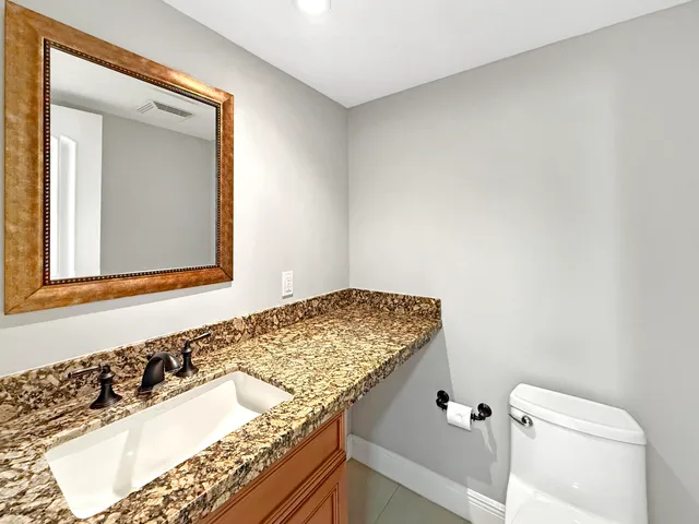 a bathroom with a granite countertop sink and a mirror