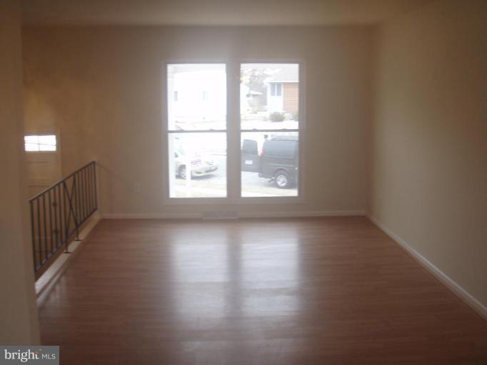 7108 Reno Road Windsor Mill, MD 21244 - Photo 6 of 29 an empty room with wooden floor and windows