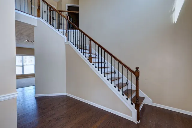 a view of staircase with wooden floor and white walls