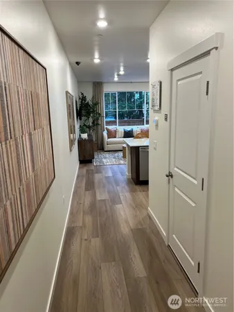 a kitchen with stainless steel appliances granite countertop a dining table chairs refrigerator and sink