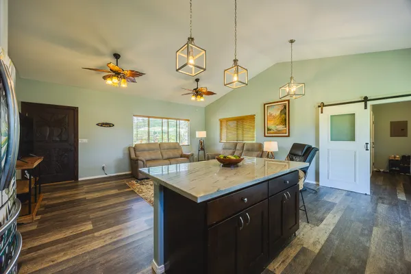 a kitchen with a stove a counter top space a sink and wooden floor