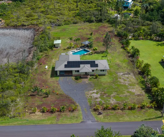 an aerial view of a house with a yard basket ball court and outdoor seating