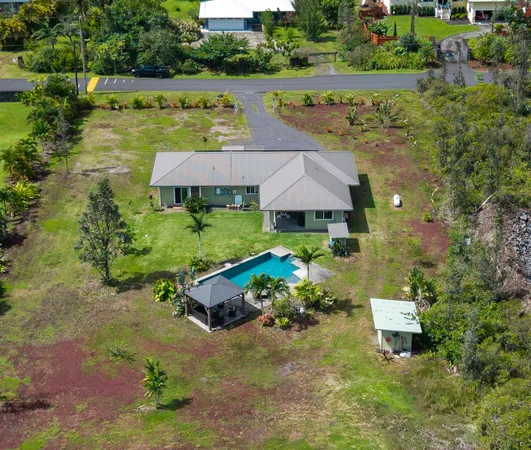 an aerial view of a house with garden space and lake view