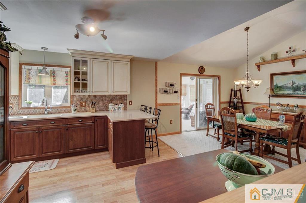501 Pinehurst Road Cream Ridge, NJ 08514 - Photo 12 of 36 a open kitchen with stainless steel appliances granite countertop a stove a sink dishwasher a dining table and chairs with wooden floor