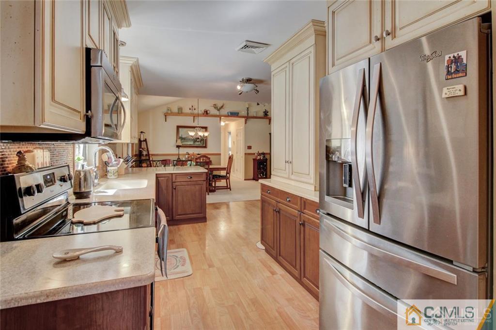 501 Pinehurst Road Cream Ridge, NJ 08514 - Photo 15 of 36 a kitchen with stainless steel appliances granite countertop a refrigerator a stove and a sink with wooden floor