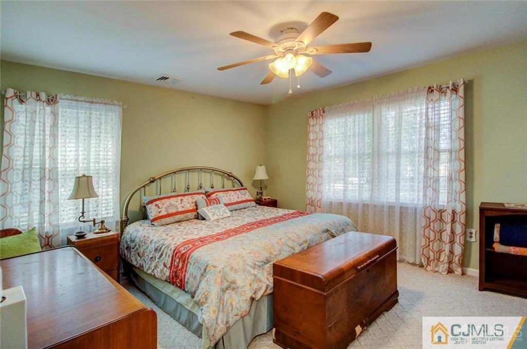 501 Pinehurst Road Cream Ridge, NJ 08514 - Photo 25 of 36 a bedroom with a bed and a chandelier