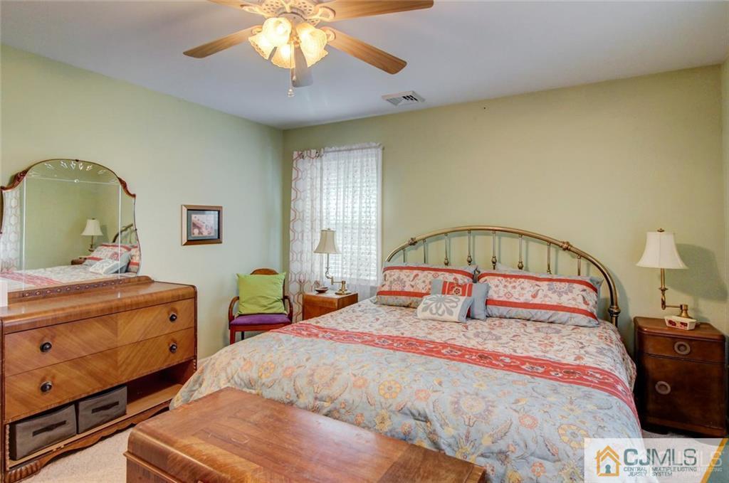 501 Pinehurst Road Cream Ridge, NJ 08514 - Photo 26 of 36 a bedroom with a bed and a chandelier
