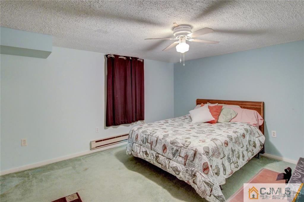 501 Pinehurst Road Cream Ridge, NJ 08514 - Photo 27 of 36 a bedroom with a bed and a chandelier