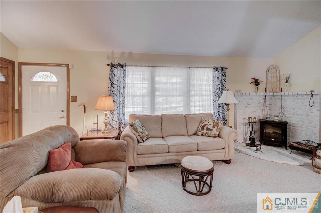 501 Pinehurst Road Cream Ridge, NJ 08514 - Photo 3 of 36 a living room with furniture a fireplace and a chandelier