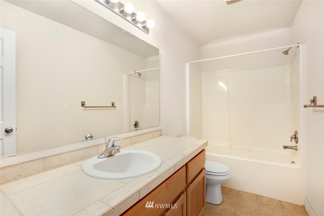 16410 Northeast 12th Court Ridgefield, WA 98642 - Photo 19 of 25 a bathroom with a granite countertop sink a toilet and shower