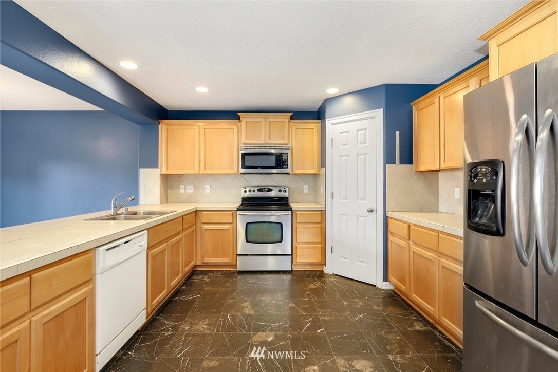 16410 Northeast 12th Court Ridgefield, WA 98642 - Photo 8 of 25 a kitchen with stainless steel appliances a refrigerator sink and stove