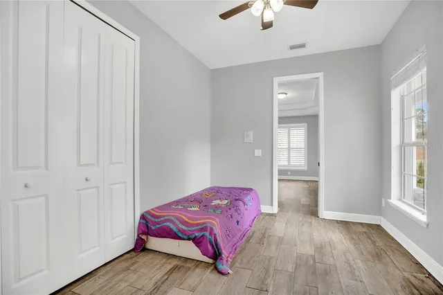 a bedroom with a bed and a chandelier fan