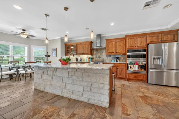 a kitchen with stainless steel appliances a stove a sink a oven a dining table and chairs