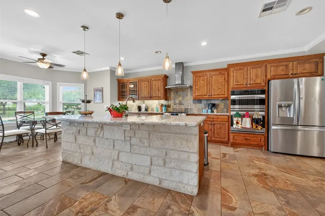 a kitchen with stainless steel appliances a stove a sink a oven a dining table and chairs