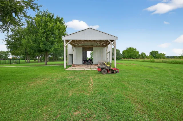 an aerial view of a house with outdoor space pool seating area and trees all around