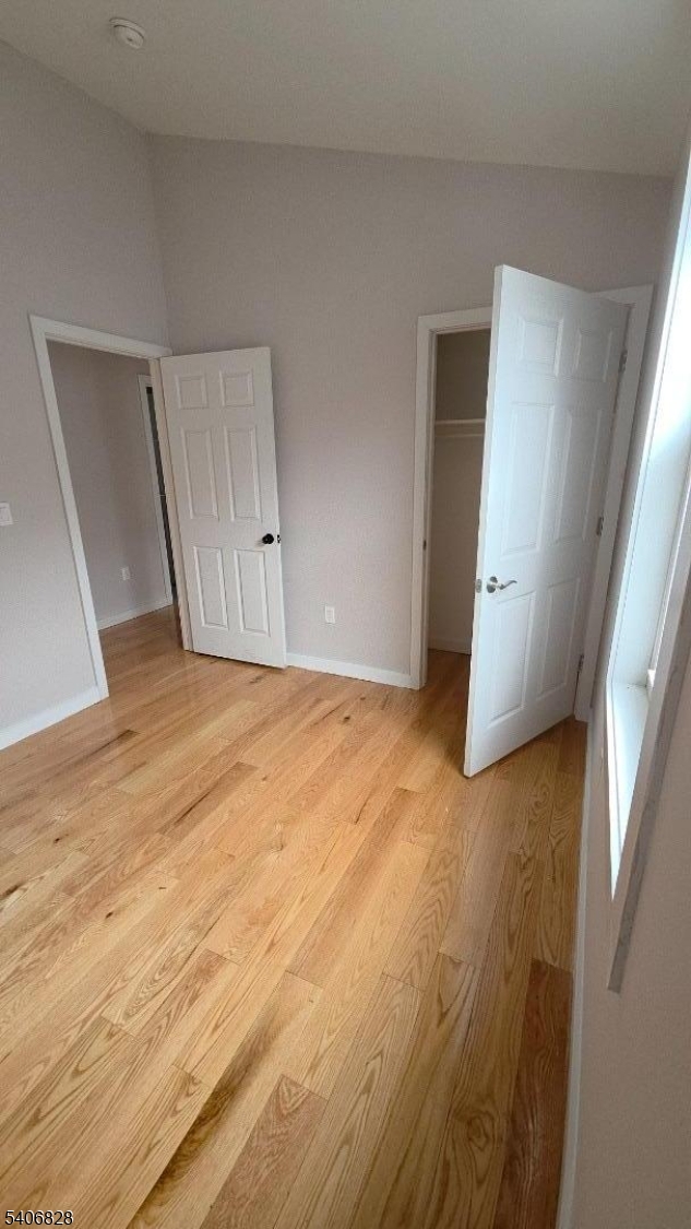 10 Shaw Avenue, Unit 2 Newark, NJ 07112 - Photo 8 of 15 a view of an empty room with wooden floor and a window