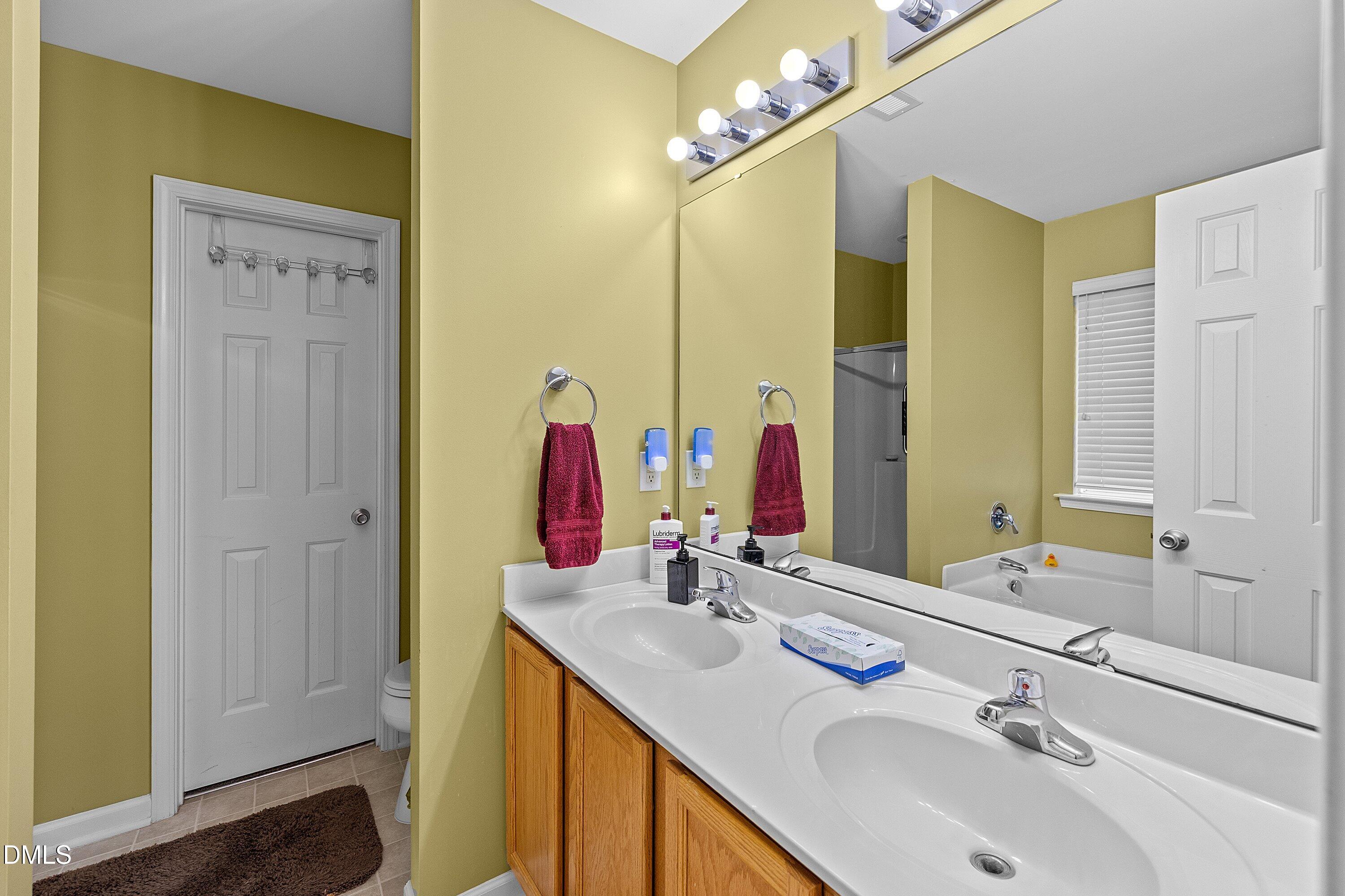 125 River Pearl Street Raleigh, NC 27603 - Photo 12 of 34 a bathroom with a double vanity sink and a mirror