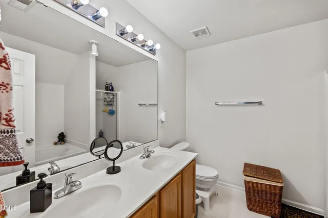 a bathroom with a sink double vanity and a toilet
