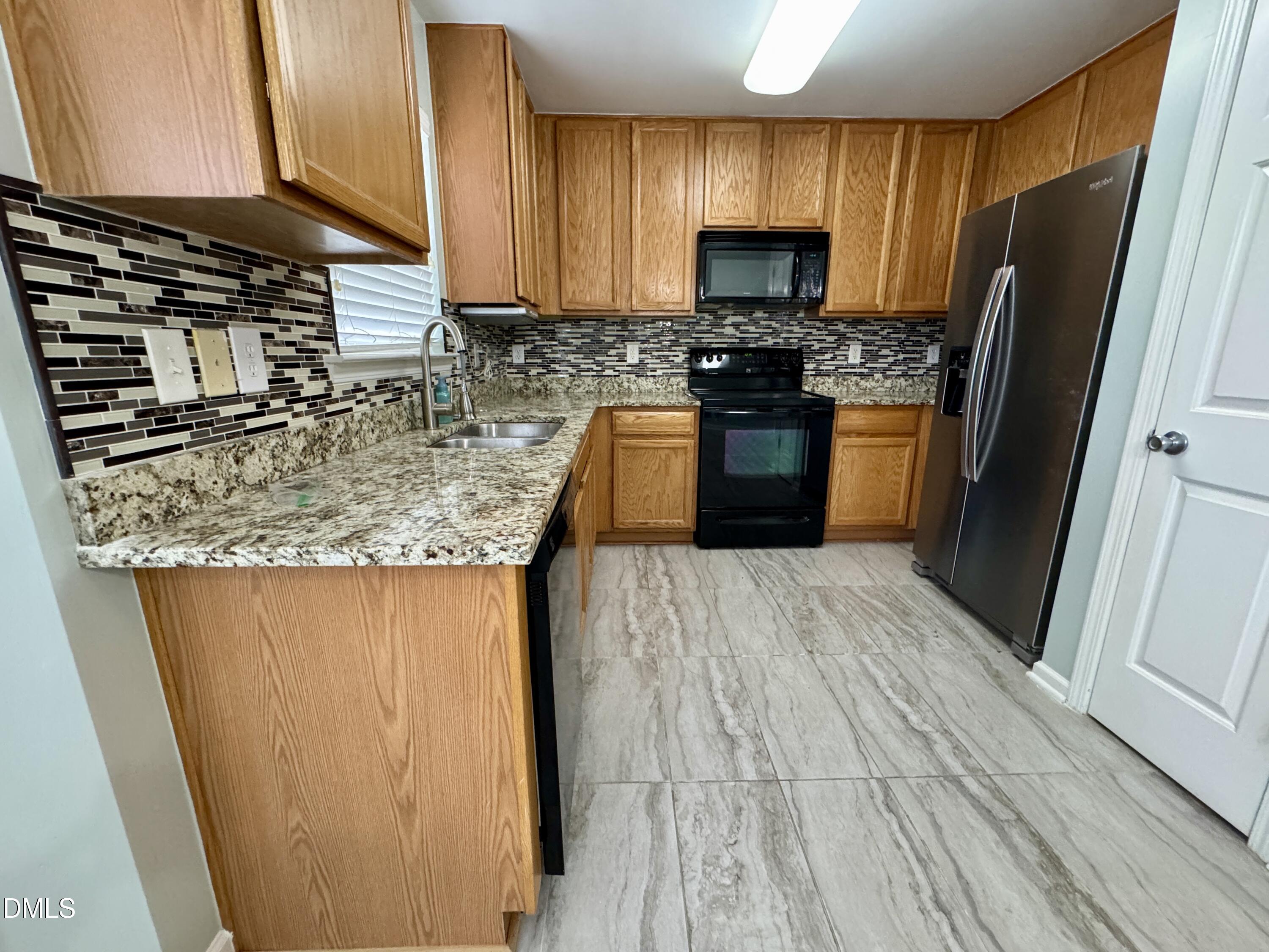 125 River Pearl Street Raleigh, NC 27603 - Photo 8 of 34 a kitchen with stainless steel appliances granite countertop a stove a sink and a microwave