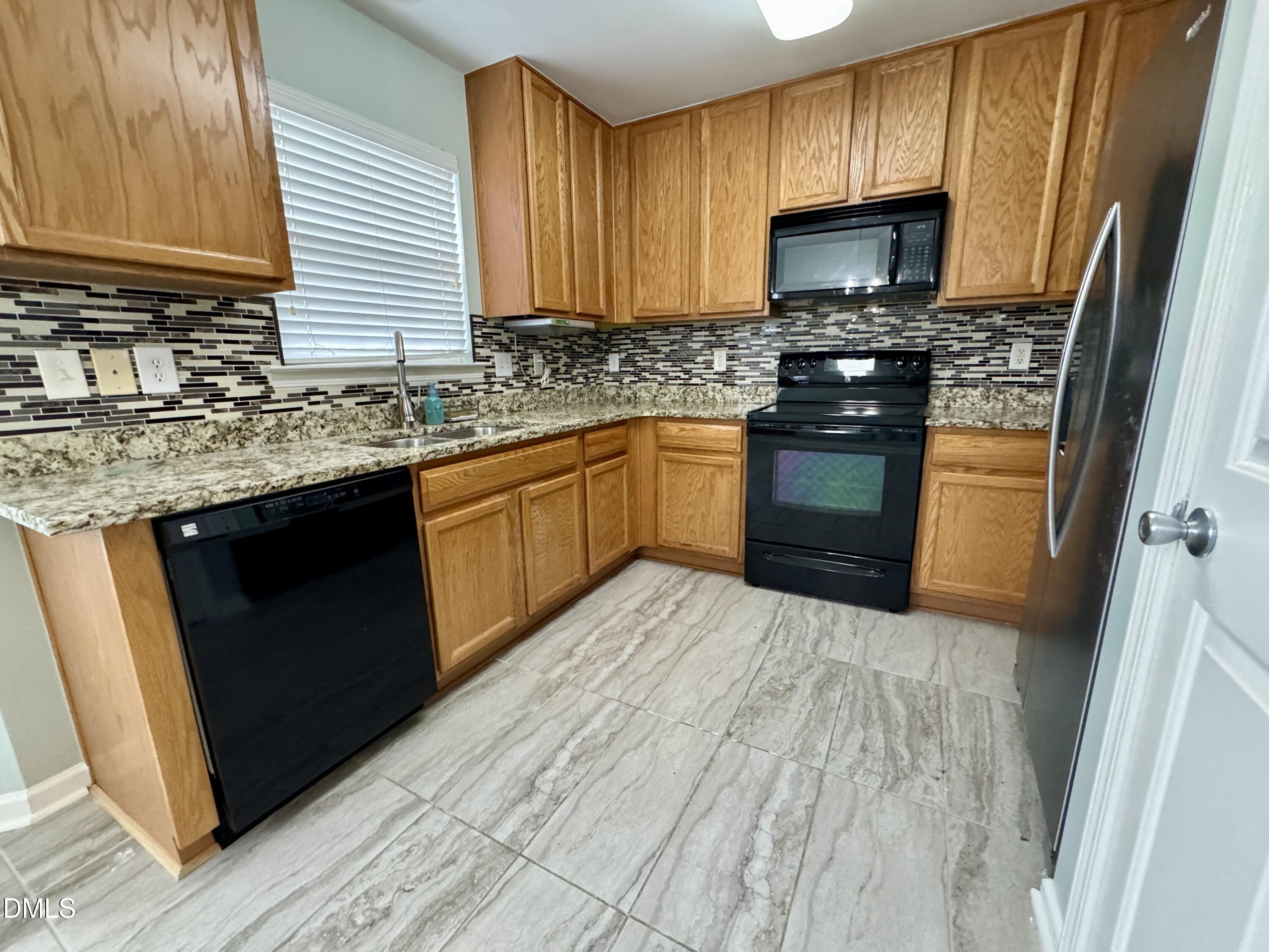 125 River Pearl Street Raleigh, NC 27603 - Photo 9 of 34 a kitchen with stainless steel appliances granite countertop a stove a sink dishwasher and a microwave oven with cabinets