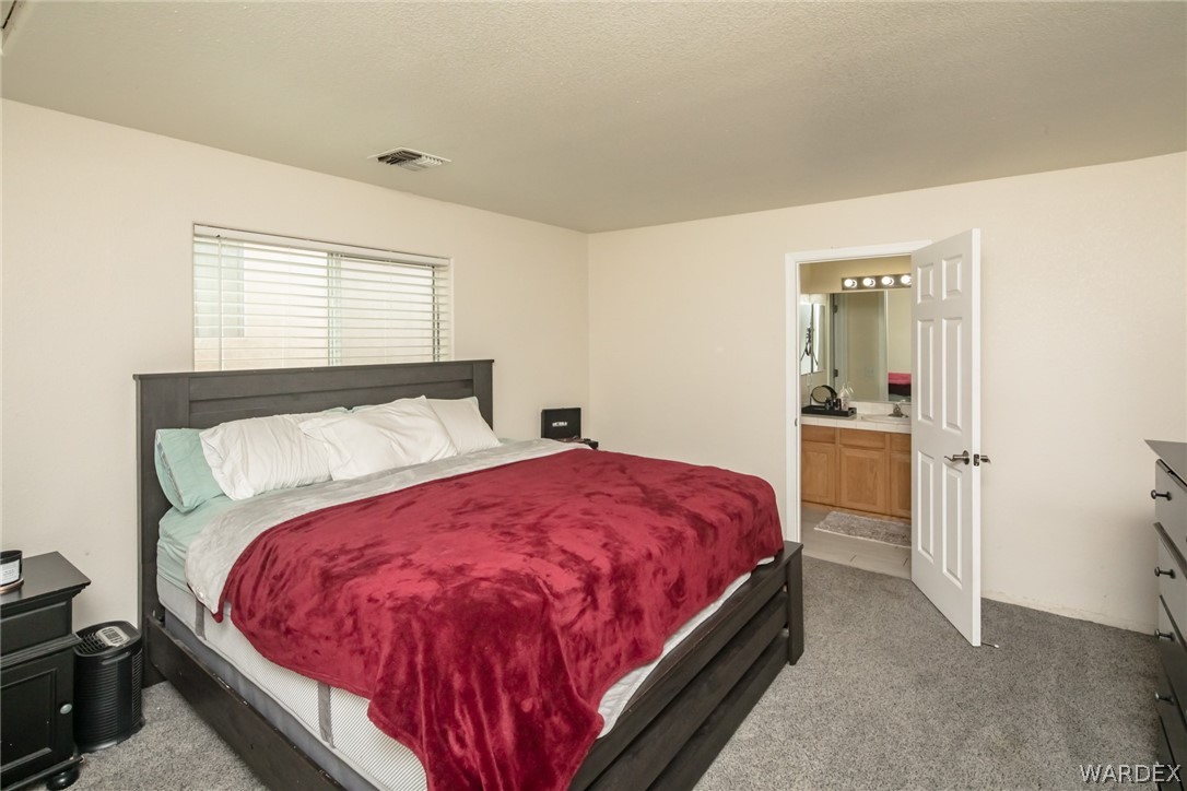 2080 Jamie Road Fort Mohave, AZ 86426 - Photo 17 of 29 a bed sitting in a bedroom next to a window and a larger closet