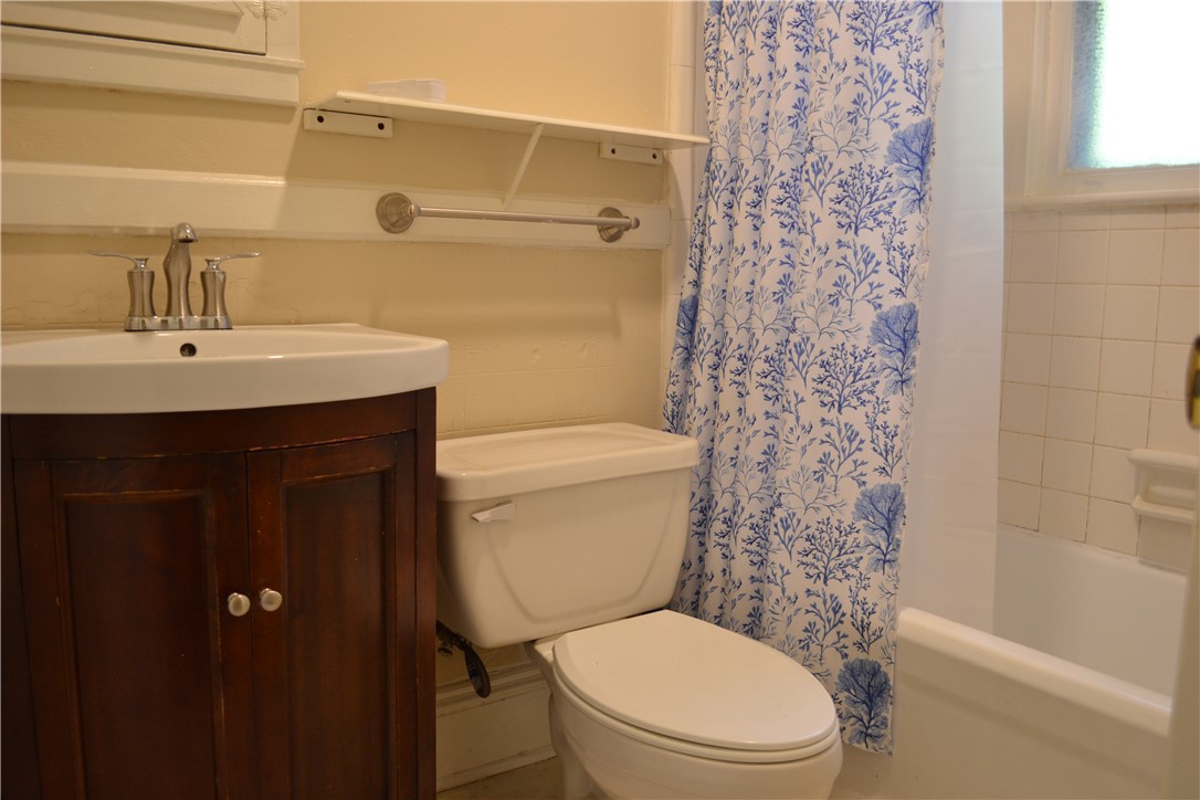 205 B East Broad Street Anderson, SC 29621 - Photo 8 of 27 This bathroom features a sleek vanity, toilet, and a combination shower-tub.