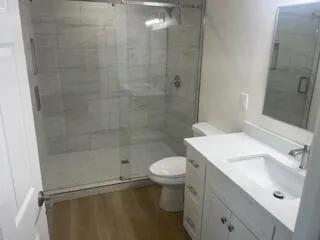 a bathroom with a sink a toilet and shower