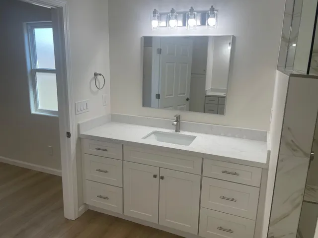a bathroom with a sink vanity and mirror