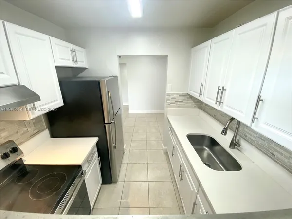 a kitchen with a refrigerator sink and wooden floor
