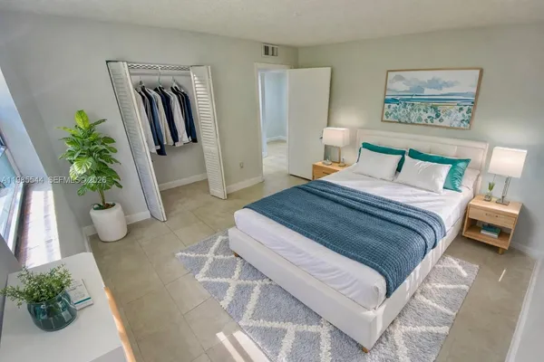 a bedroom with a large bed and potted plant