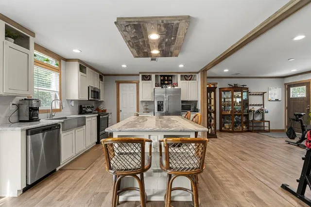 a kitchen with stainless steel appliances granite countertop a stove a refrigerator a sink dishwasher with a dining table and chairs