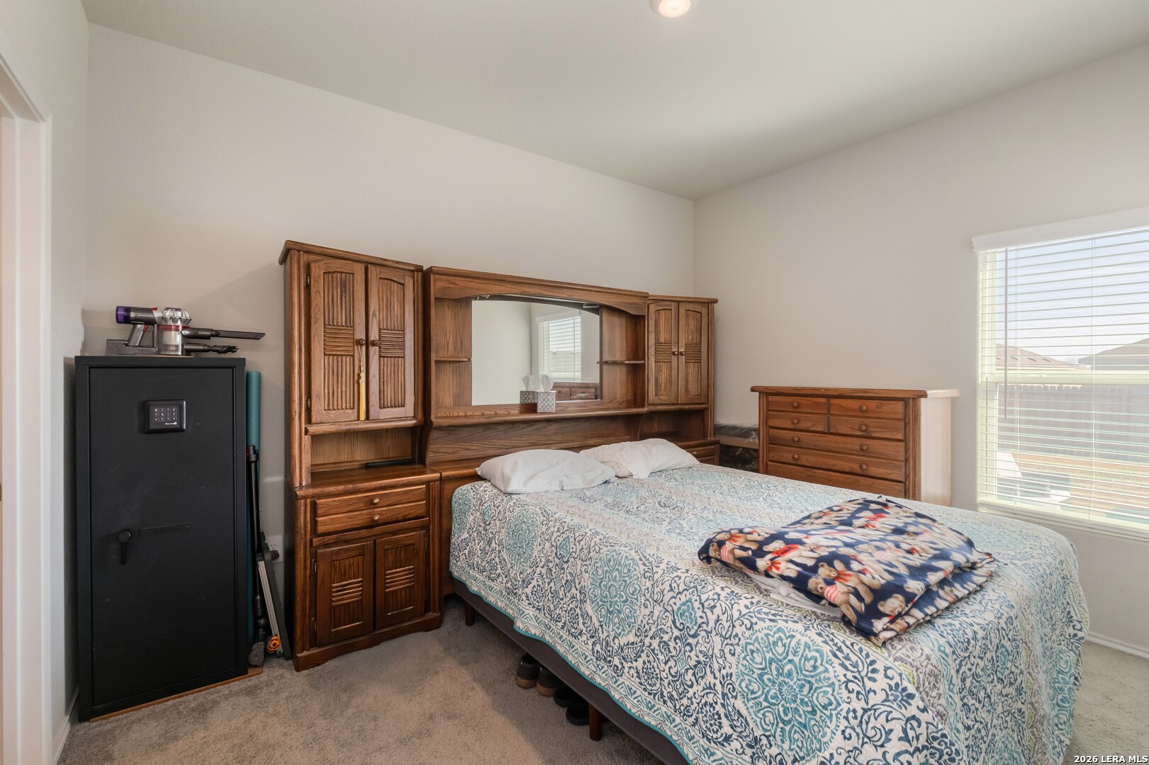3505 Sky Place Seguin, TX 78155 - Photo 20 of 30 a bedroom with a bed and dresser with mirror