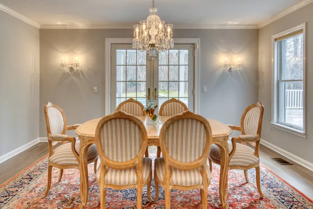 a view of a dining room with furniture a chandelier and wooden floor