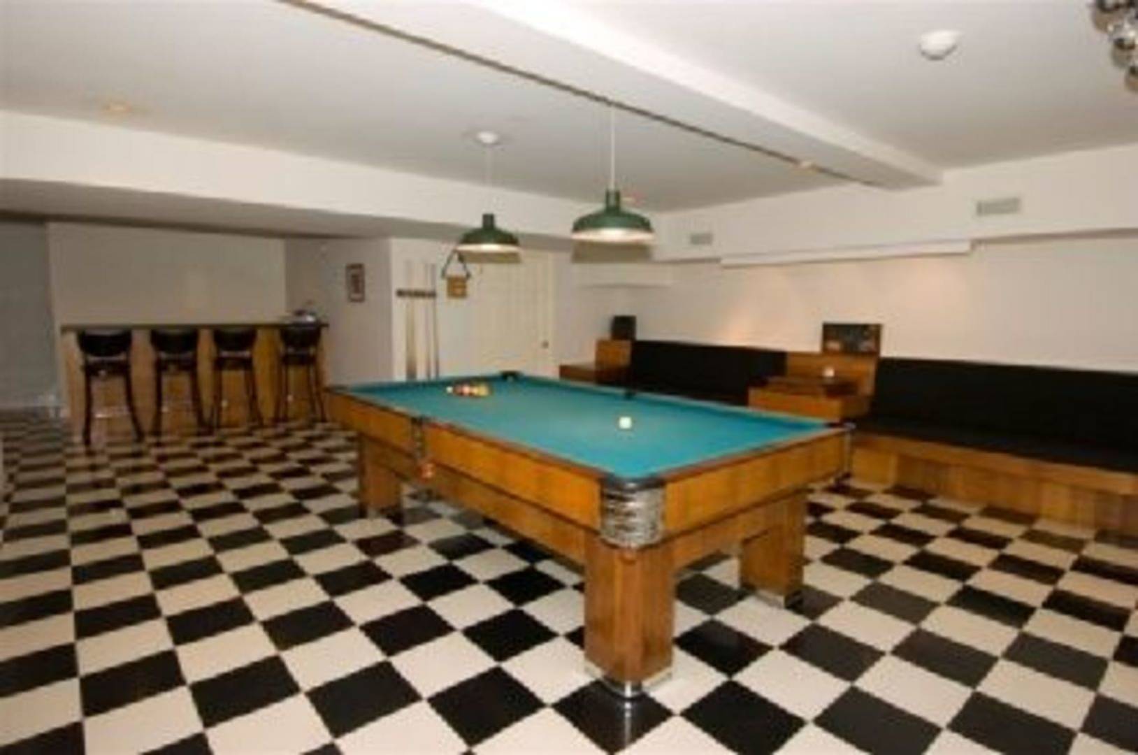 1611 Deerfield Road Water Mill, NY 11976 - Photo 22 of 22 a living room with a black white checkered floor with a gaming machine and dining chairs
