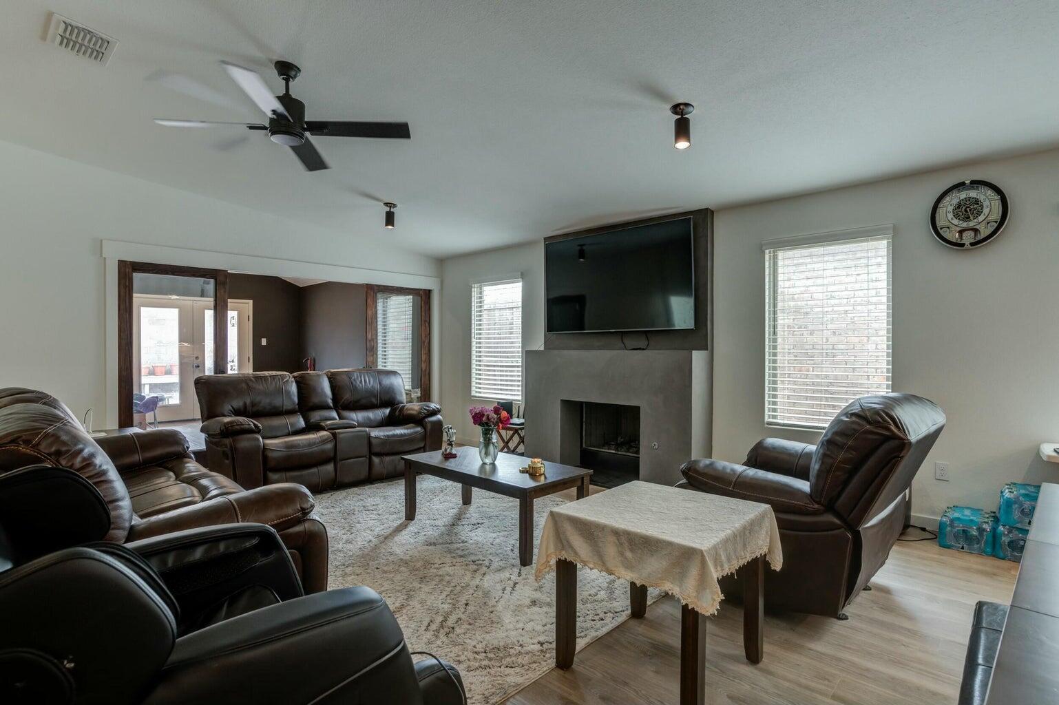 3711 128th Street Lubbock, TX 79423 - Photo 12 of 42 a living room with furniture a fireplace and a flat screen tv