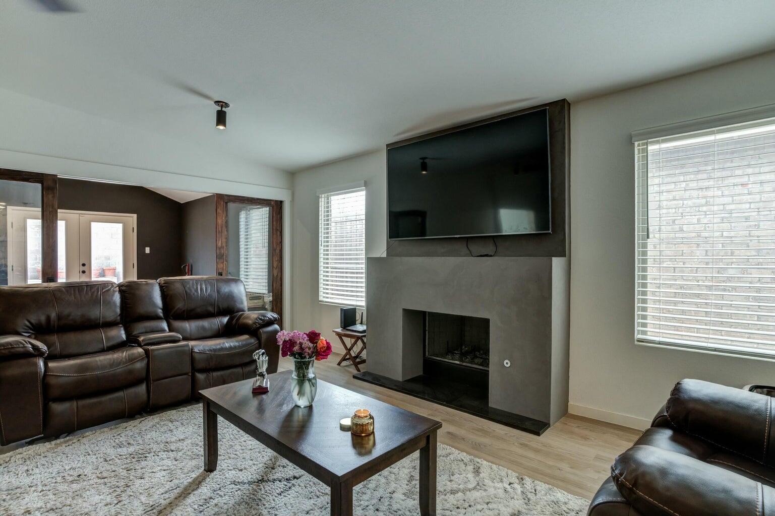 3711 128th Street Lubbock, TX 79423 - Photo 13 of 42 a living room with furniture a flat screen tv and a fireplace