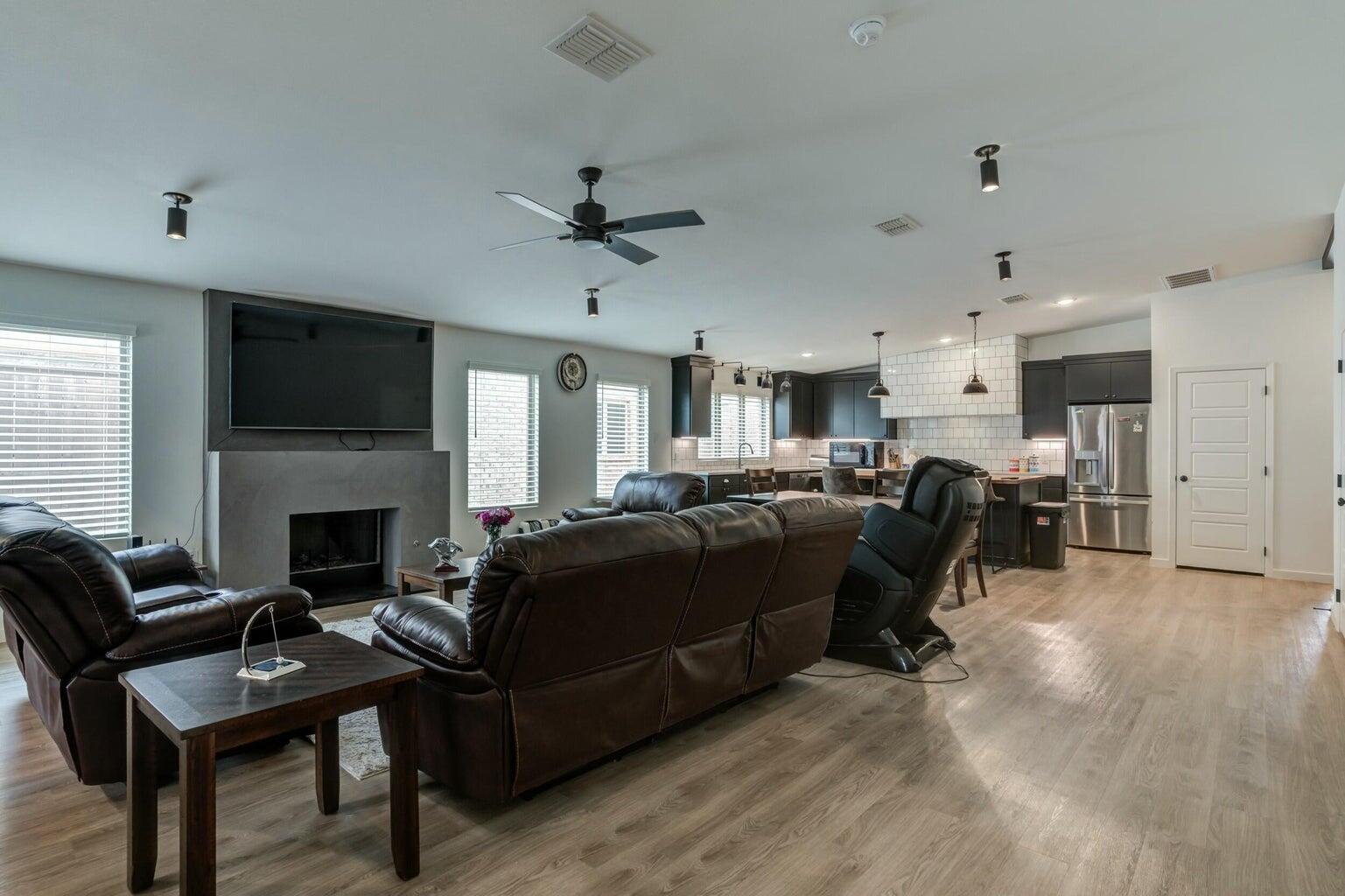 3711 128th Street Lubbock, TX 79423 - Photo 16 of 42 a living room with furniture a fireplace and a flat screen tv
