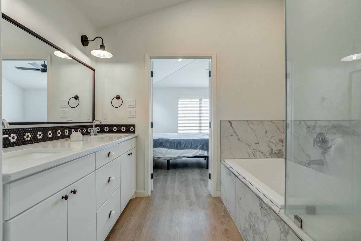 3711 128th Street Lubbock, TX 79423 - Photo 24 of 42 a bathroom with a tub a double vanity sink and mirror