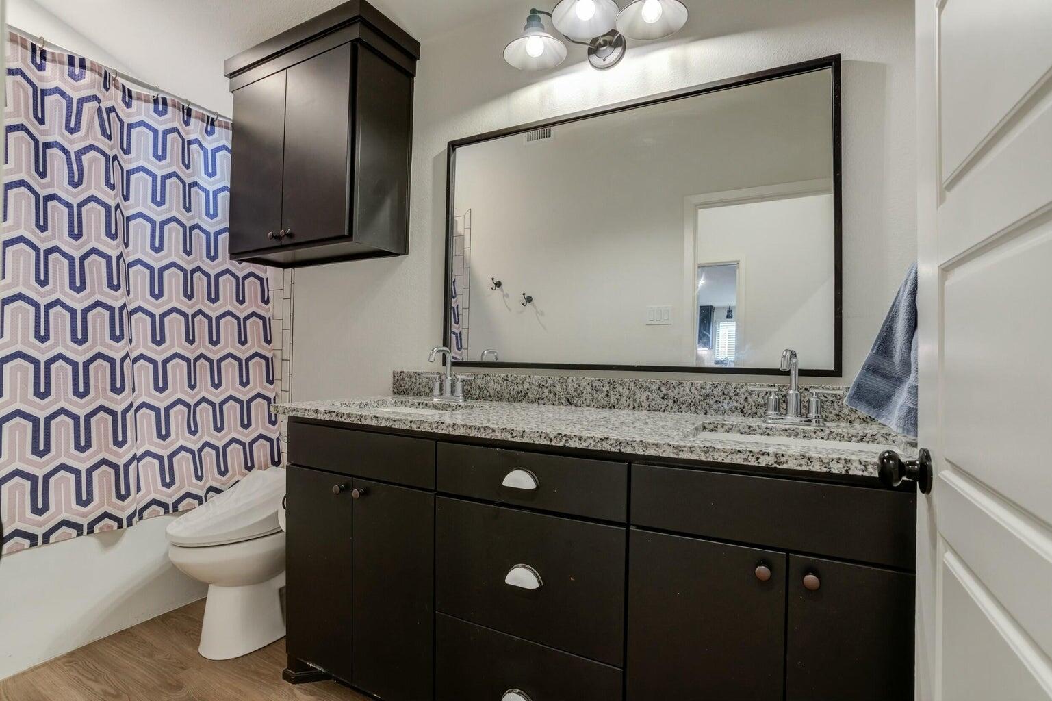 3711 128th Street Lubbock, TX 79423 - Photo 29 of 42 a bathroom with a granite countertop toilet sink and mirror