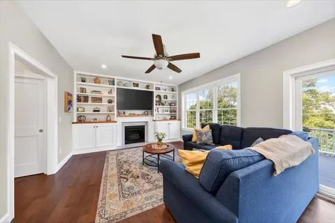 a living room with furniture a fireplace and a flat screen tv